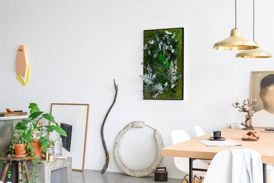 Wohnbereich mit natürlicher Dekoration und Pflanzenbild ans der Wand