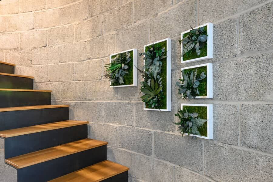 Pflanzenbiler verschiedener Größen als Dekoration über der Treppe
