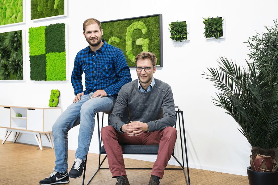 Die Gründer von styleGREEN Lukas und Niklas mit Moosbildern im Hintergrund